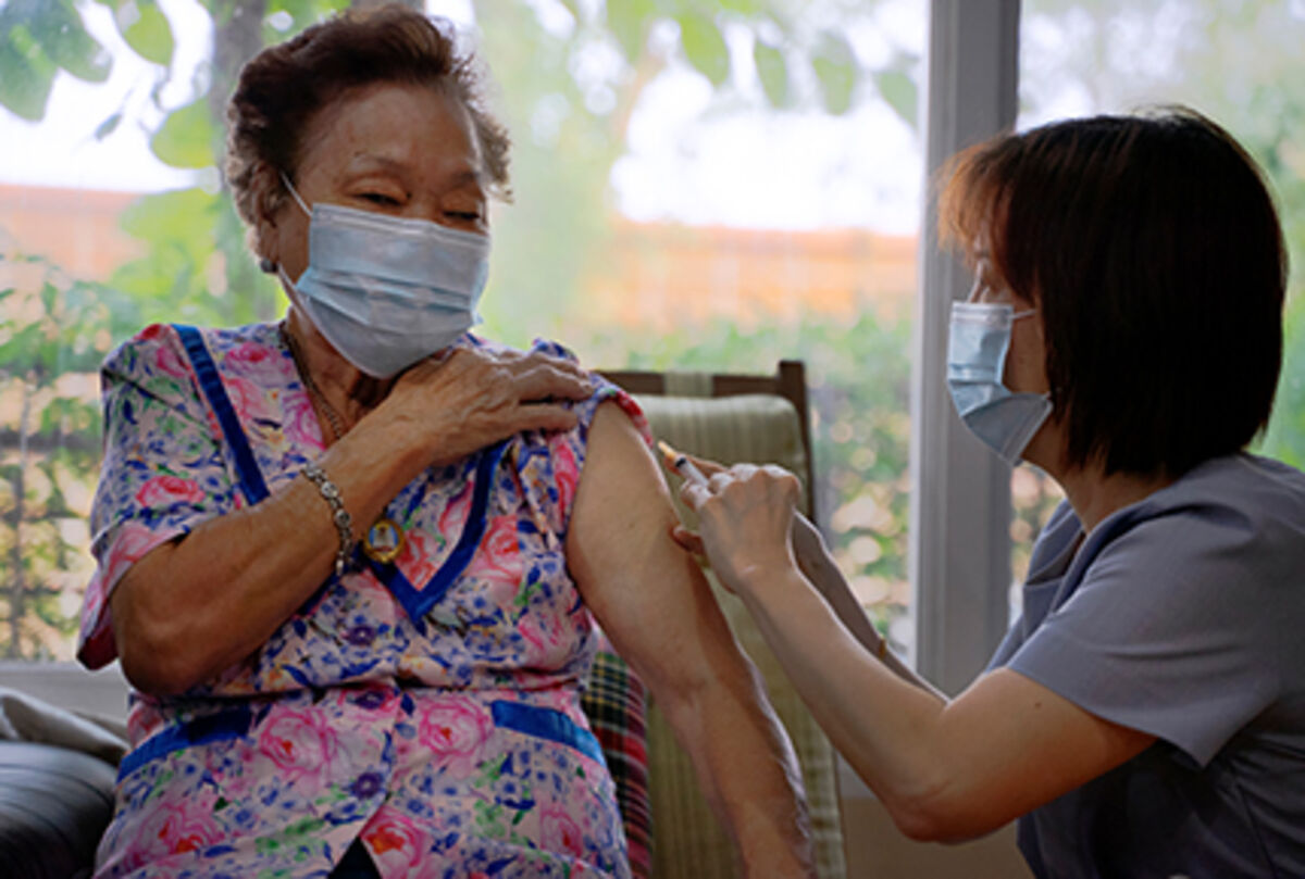 Senior adult receiving a vaccination from a health care professional