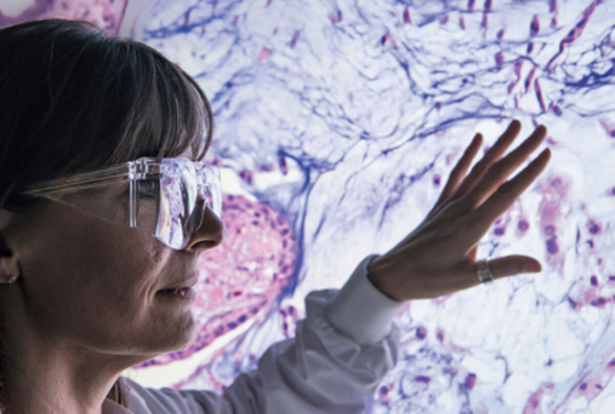 Scientist examining cross section of cells from tumour biopsy